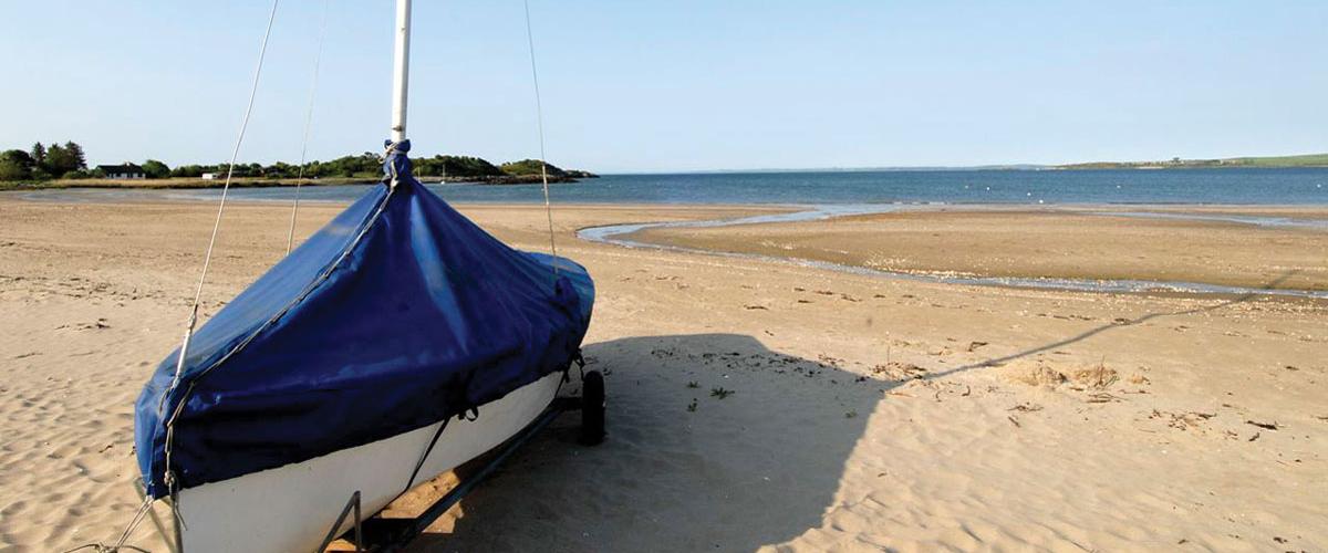 A sailing boat on the private beach at Sandgreen